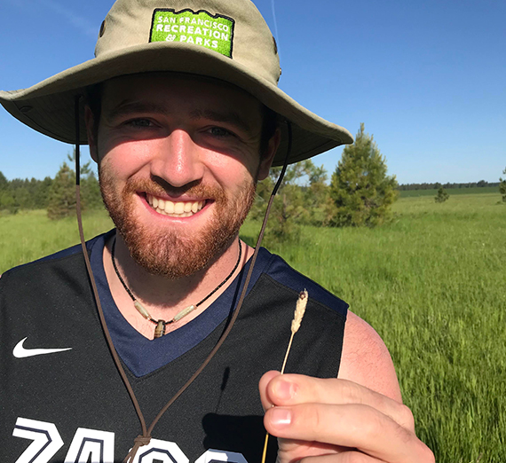 女性が複数のカヤックの横に立っている。